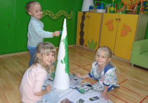 Dzieci malują farbami choinkę z papieru